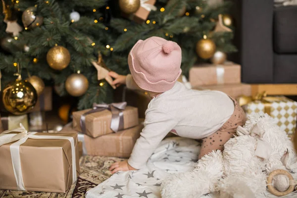 Menina brinca com brinquedos sob a árvore de Natal — Fotografia de Stock