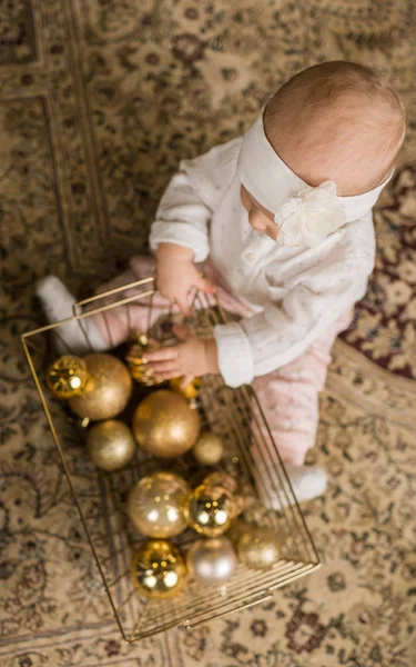 Menina brinca com uma cesta de brinquedos de Natal perto do Chris — Fotografia de Stock