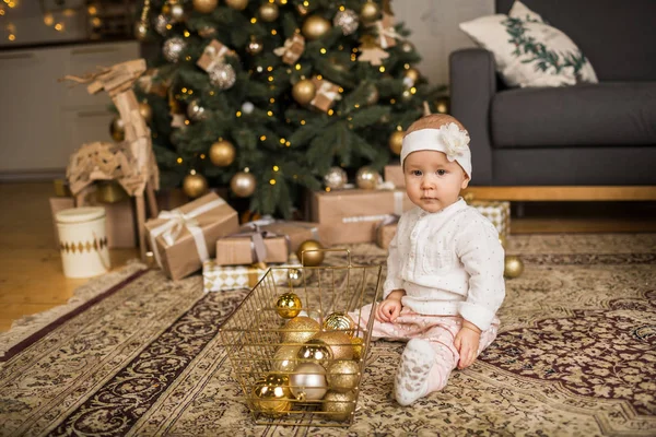 Menina brinca com uma cesta de brinquedos de Natal perto do Chris — Fotografia de Stock