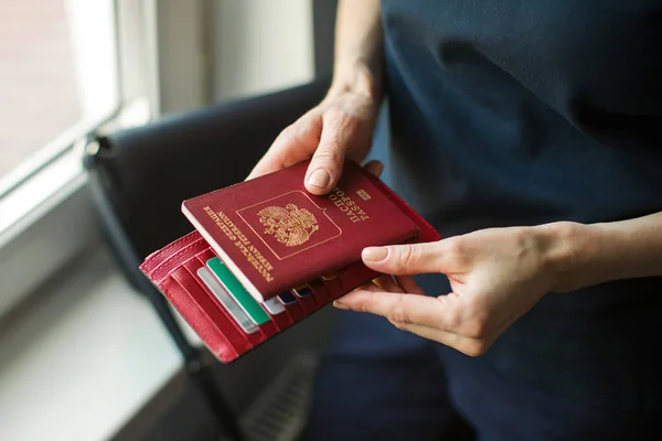 Kvinna Innehar Utländska Pass Hemma Vid Fönstret — Stockfoto