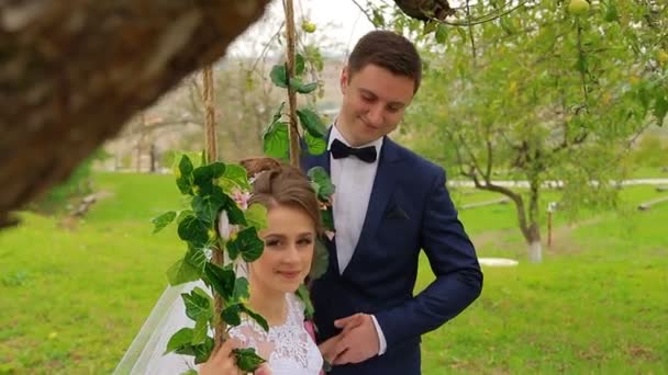 De bruid zit op een mooie schommel — Stockvideo