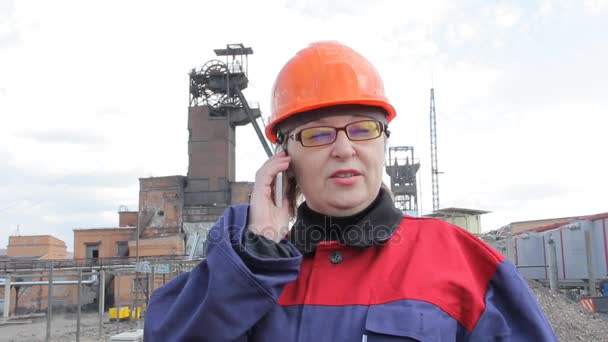 Femme en vêtements de travail d'un mineur parlant au téléphone dans le fond d'une mine de charbon — Video