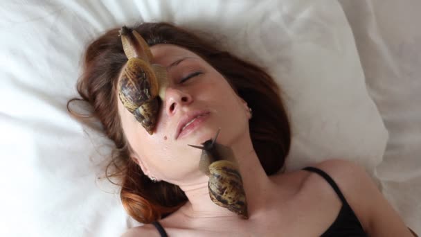 Une jeune femme au spa reçoit un massage facial avec des escargots africains Achatina. Les escargots mangent la peau morte des produits. Au final, il laisse la peau lisse et fraîche . — Video