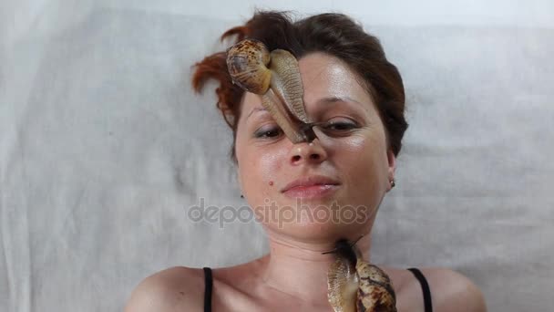 Une jeune femme au spa reçoit un massage facial avec des escargots africains Achatina. Les escargots mangent la peau morte des produits. Au final, il laisse la peau lisse et fraîche . — Video