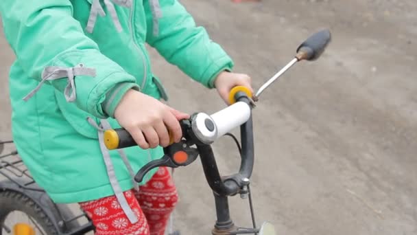 Мальчик и девочка в весенней поездке на двухколесном велосипеде на улице перед загородным домом — стоковое видео
