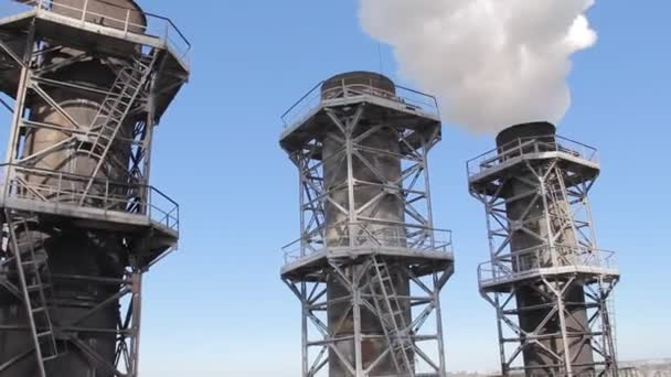 Weißer Rauch quillt aus den Werksrohren gegen den blauen Himmel — Stockvideo