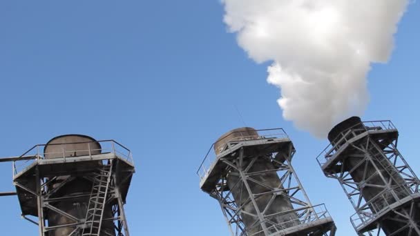 Λευκό καπνό που προέρχεται από το εργοστάσιο σωλήνων ενάντια στον γαλάζιο ουρανό — Αρχείο Βίντεο