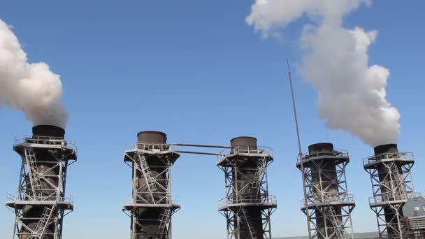 Witte rook komt uit de fabriek leidingen tegen de blauwe hemel — Stockvideo