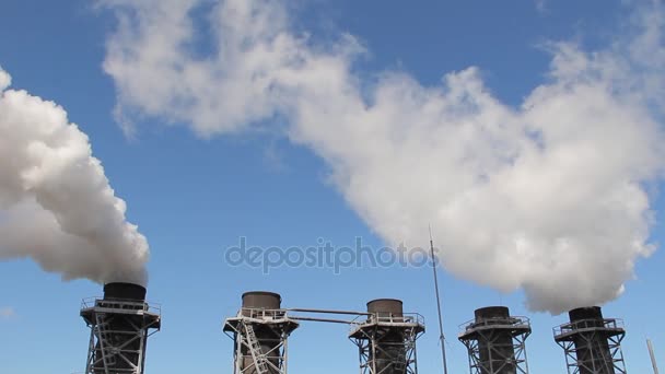 Vit rök kommer från fabriken rören mot den blå himlen — Stockvideo