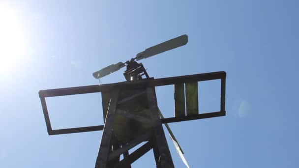 The windmill pumped water in Siberia against the blue sky. — Stock Video