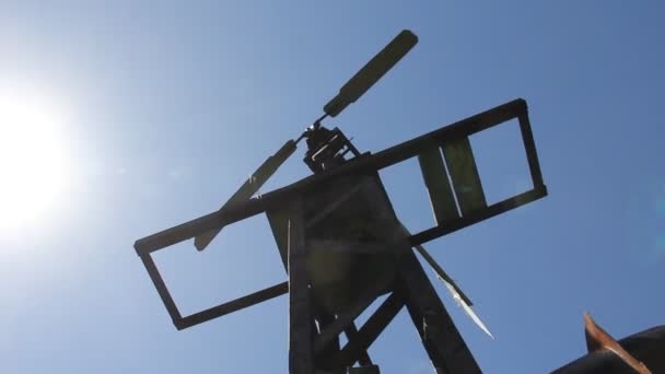 The windmill pumped water in Siberia against the blue sky. — Stock Video