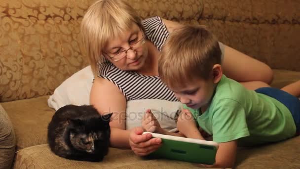 Uma Mulher Com Filho Lendo Livro Deitado Sofá — Vídeo de Stock