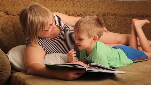 Een Vrouw Met Een Kind Lezen Van Een Boek Liggend — Stockvideo