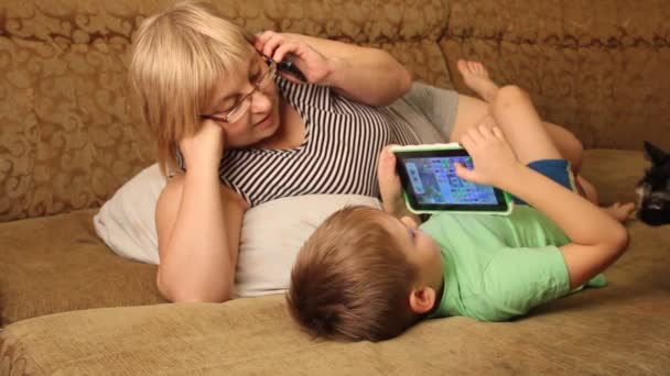 Una Mujer Con Niño Leyendo Libro Acostado Sofá — Vídeos de Stock