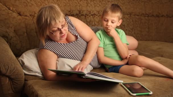 Una Donna Con Bambino Che Legge Libro Sdraiato Sul Divano — Video Stock