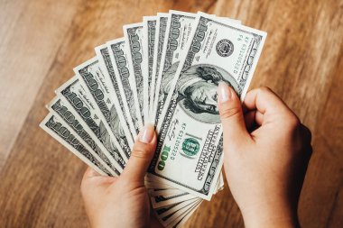 Ahşap arka planda 100 dolarlık banknotlar