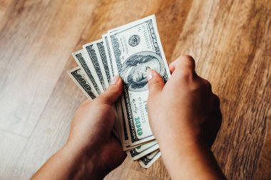 Ahşap arka planda 100 dolarlık banknotlar
