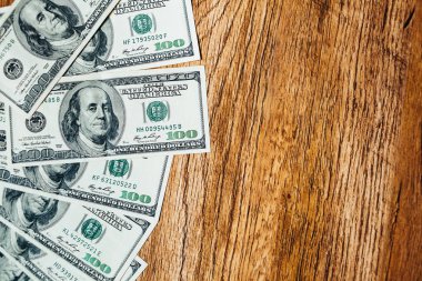 Ahşap arka planda 100 dolarlık banknotlar