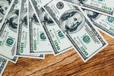 Ahşap arka planda 100 dolarlık banknotlar