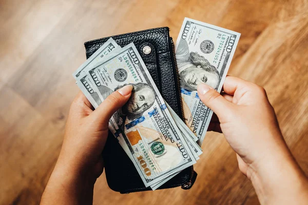 Ahşap arka planda 100 dolarlık banknotlar
