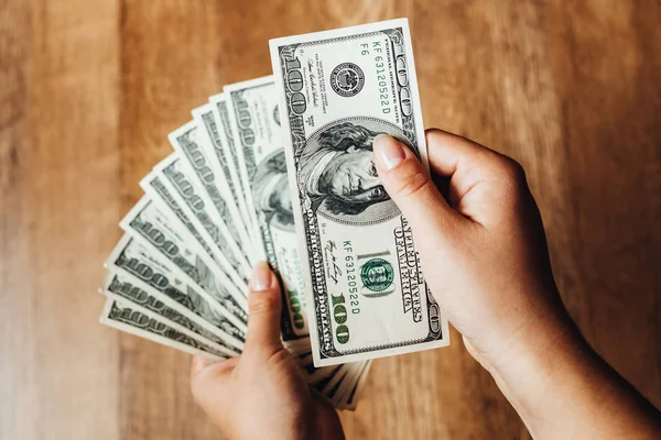 Ahşap arka planda 100 dolarlık banknotlar