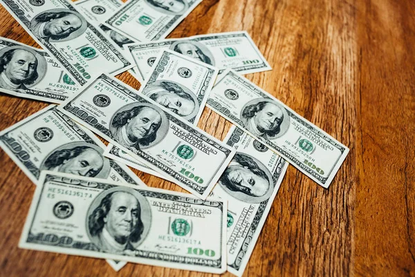 Hundred dollar bills on a wooden background — Stock Photo, Image