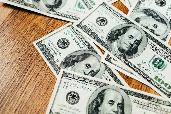 Ahşap arka planda 100 dolarlık banknotlar