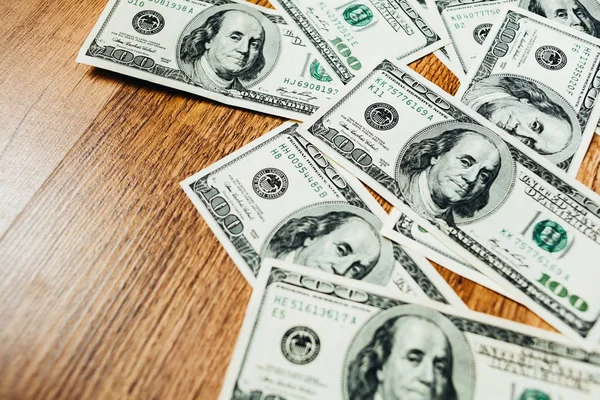 Ahşap arka planda 100 dolarlık banknotlar