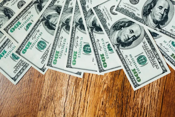 Ahşap arka planda 100 dolarlık banknotlar