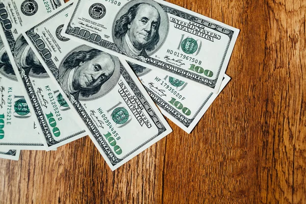 Ahşap arka planda 100 dolarlık banknotlar