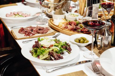 Lokantada aperatifler, salatalar ve şaraplarla dolu bir ziyafet için servis edildi.