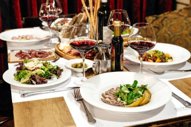 Lokantada aperatifler, salatalar ve şaraplarla dolu bir ziyafet için servis edildi.