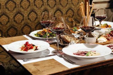 Lokantada aperatifler, salatalar ve şaraplarla dolu bir ziyafet için servis edildi.