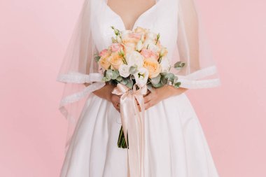 Düğün resmi ve kırmızı çiçekli bir gelin buketi.