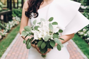 Düğün resmi ve kırmızı çiçekli bir gelin buketi.