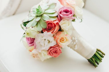 Düğün resmi ve kırmızı çiçekli bir gelin buketi.