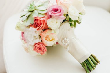 Düğün resmi ve kırmızı çiçekli bir gelin buketi.