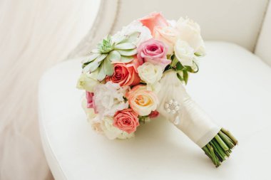 Düğün resmi ve kırmızı çiçekli bir gelin buketi.