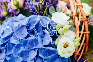 Düğün resmi ve kırmızı çiçekli bir gelin buketi.