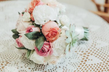 Düğün resmi ve kırmızı çiçekli bir gelin buketi.