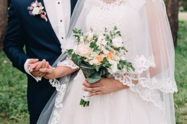 Düğün resmi ve kırmızı çiçekli bir gelin buketi.