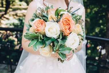 Düğün resmi ve kırmızı çiçekli bir gelin buketi.