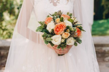 Düğün resmi ve kırmızı çiçekli bir gelin buketi.