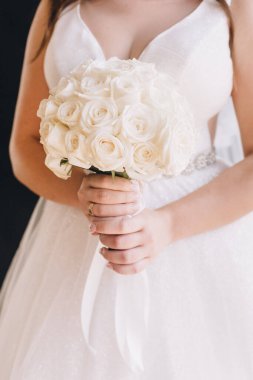 Düğün resmi ve kırmızı çiçekli bir gelin buketi.