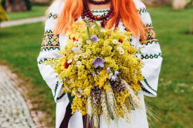 Düğün resmi ve kırmızı çiçekli bir gelin buketi.