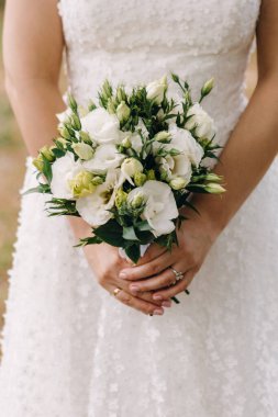 Düğün resmi ve kırmızı çiçekli bir gelin buketi.