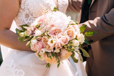 Düğün resmi ve kırmızı çiçekli bir gelin buketi.