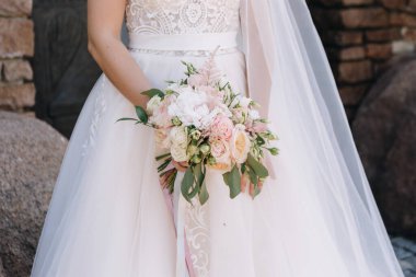 Düğün resmi ve kırmızı çiçekli bir gelin buketi.