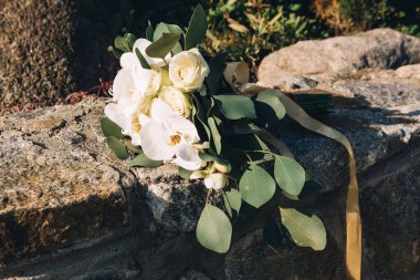 Düğün resmi ve kırmızı çiçekli bir gelin buketi.