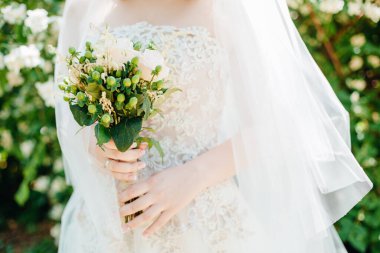 Düğün resmi ve kırmızı çiçekli bir gelin buketi.